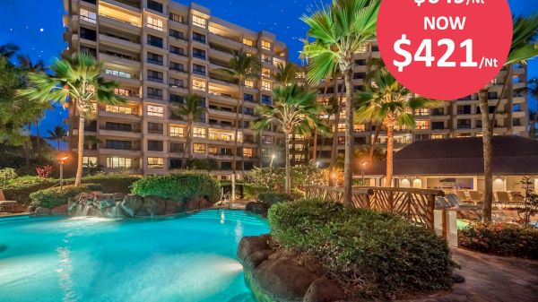A resort at night featuring a pool, lush greenery, and tall buildings, with a red discount sign showing a price reduction from $649 to $421 per night.