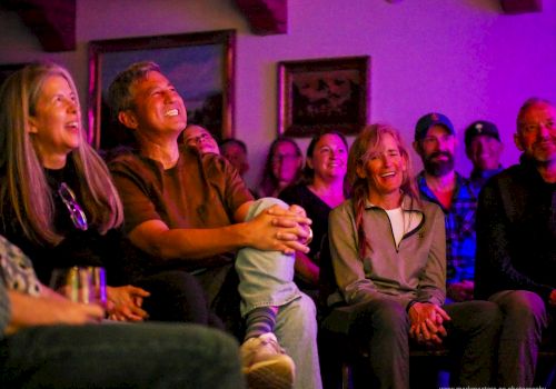 A group of people watching a show in a cozy, colorful living room; everyone smiling and laughing together.