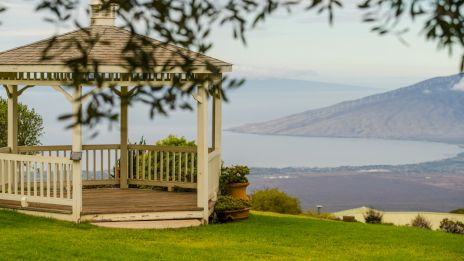 The image features a gazebo overlooking a scenic landscape with water and hills in the background, suggesting a peaceful setting.