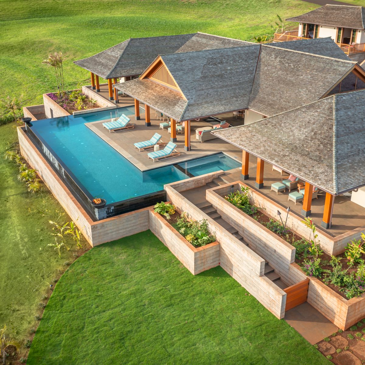 The image features a luxurious modern villa with a pool, surrounded by lush greenery and landscaped gardens. It looks serene.