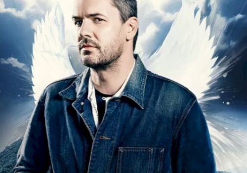 A man in a denim jacket is highlighted against a backdrop with clouds and angel wings, exuding a dramatic and mystical atmosphere.
