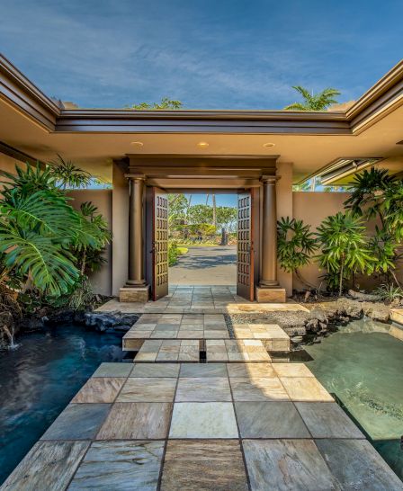 The image features a tranquil pathway lined with green plants, leading to an open space with natural light and a serene atmosphere.