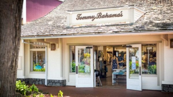 The image depicts the entrance of a Tommy Bahama's store with open doors, showcasing clothing and merchandise inside.