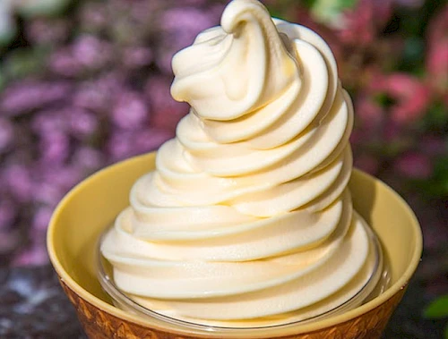 Soft-serve vanilla ice cream swirled high in a cone, creamy and smooth, ready to enjoy.