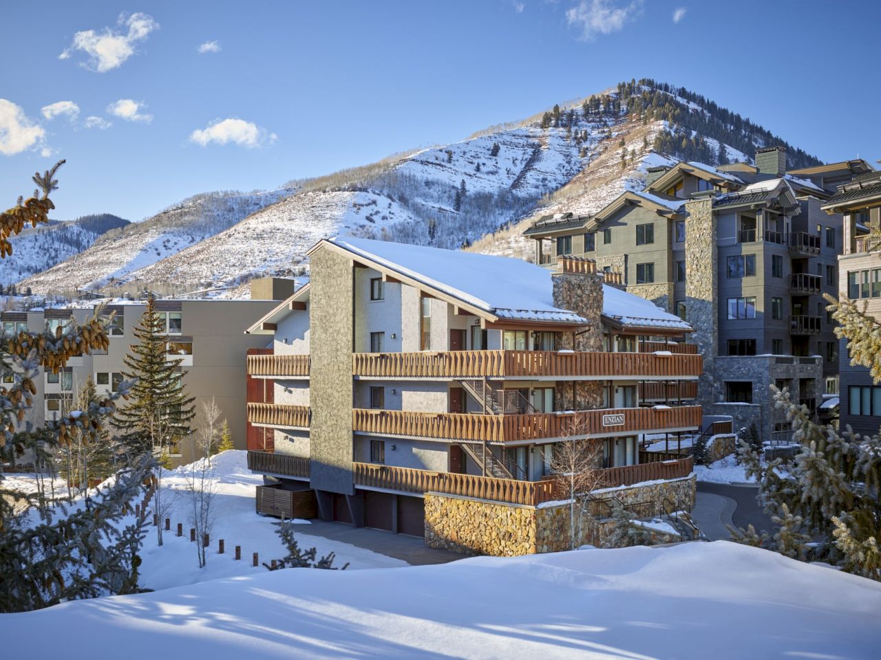 A picturesque snowy landscape featuring modern buildings nestled among mountains, showcasing winter beauty and cozy architecture.