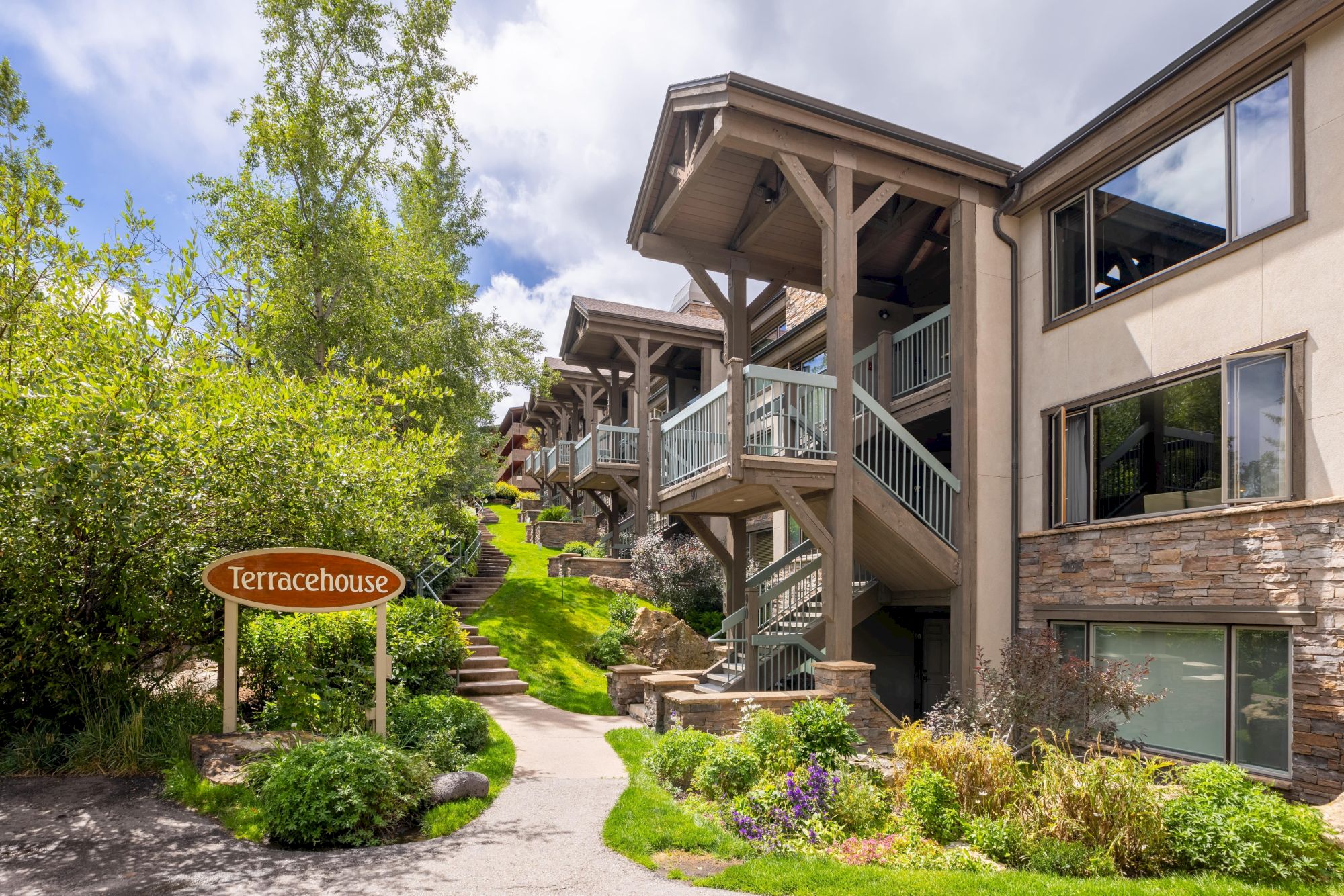 The image shows the exterior of a building named "Terracehouse," featuring green landscaping and modern architecture.