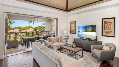 A bright living room opens to a balcony with a dining set; modern furniture, TV, framed art, and a cozy neutral palette. End.