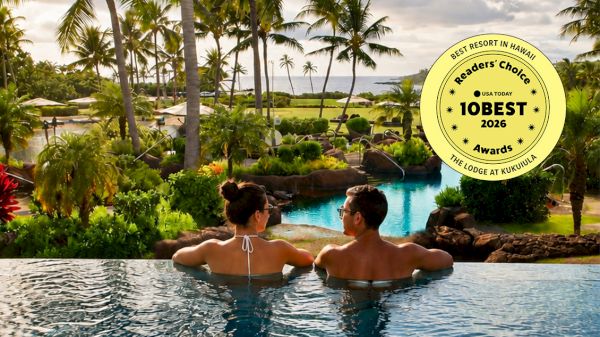Two people lounging in an infinity pool overlooking tropical palm trees and a resort landscape, with a Best of 2026 award badge in the corner.